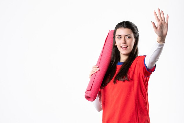 Front view young female in sport clothes with yoga mat on white wall