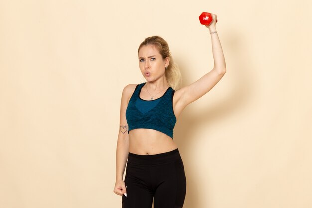 Front view young female in sport outfit holding dumbbells