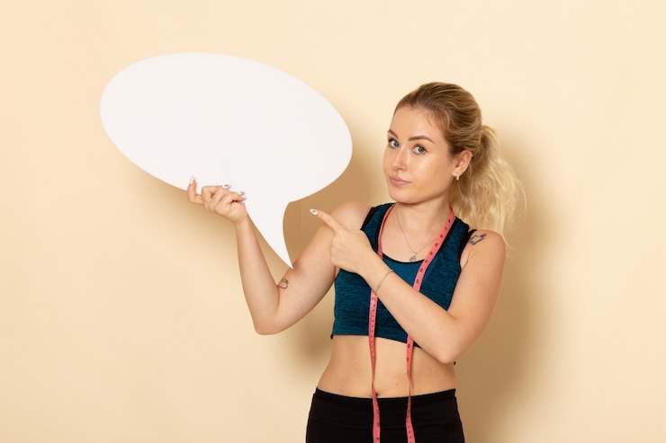 Free Photo front view young female in sport outfit holding white sign  fit