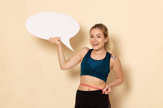 Front view young female in sport outfit holding white sign o