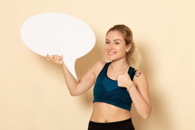 Free photo front view young female in sport outfit holding white sign