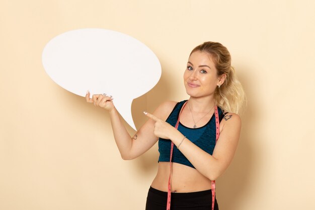 Front view young female in sport outfit holding white sign