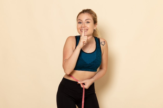 Front view young female in sport outfit measuring her body