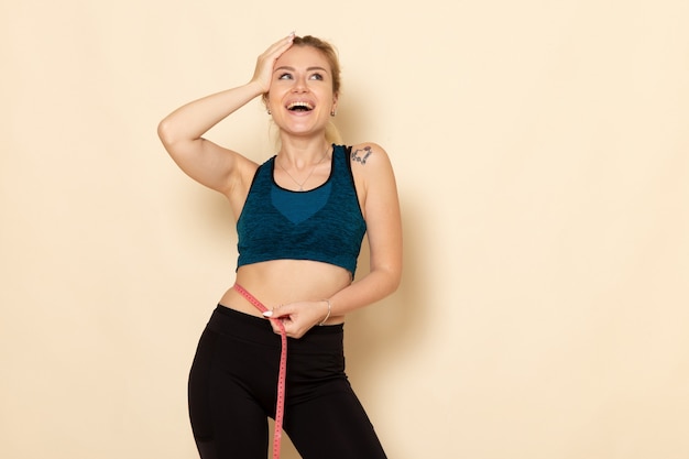 Front view young female in sport outfit measuring her body