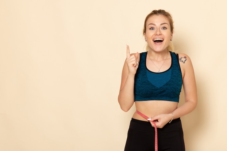 Free Photo front view young female in sport outfit measuring her body