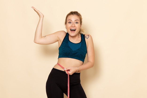 front view young female in sport outfit measuring her body