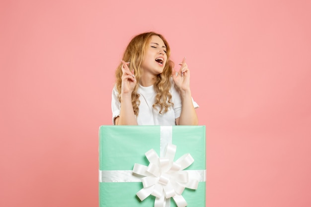 Front view young female standing inside blue present box hoping