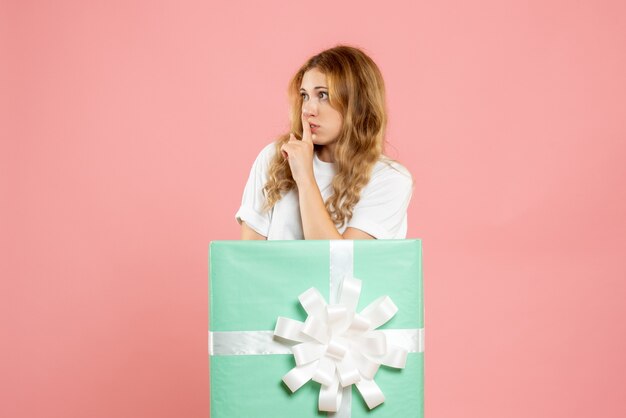 青いプレゼントボックスの中に立っている正面図若い女性