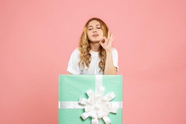 Front view young female standing inside blue present box