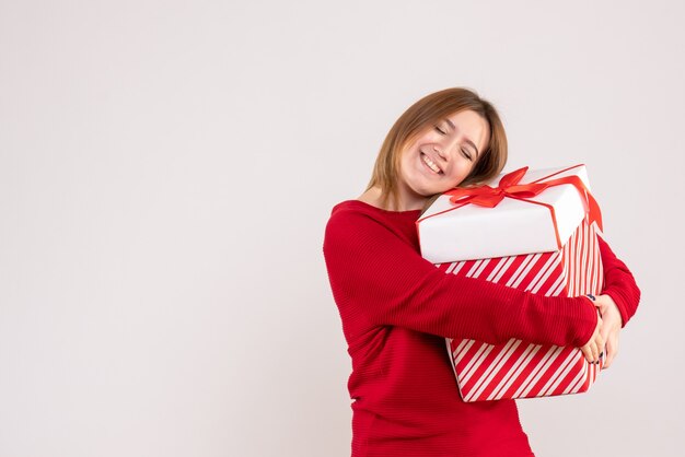 Front view young female standing with present box in her hands