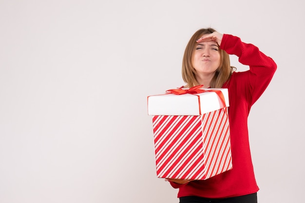 Front view young female standing with present box in her hands