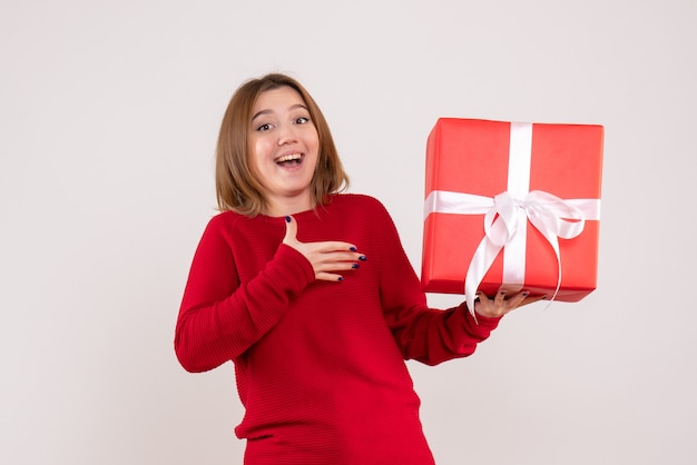 Front view young female standing with present box in her hands