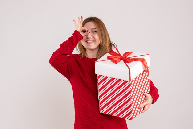 彼女の手にプレゼントを持って立っている正面図若い女性