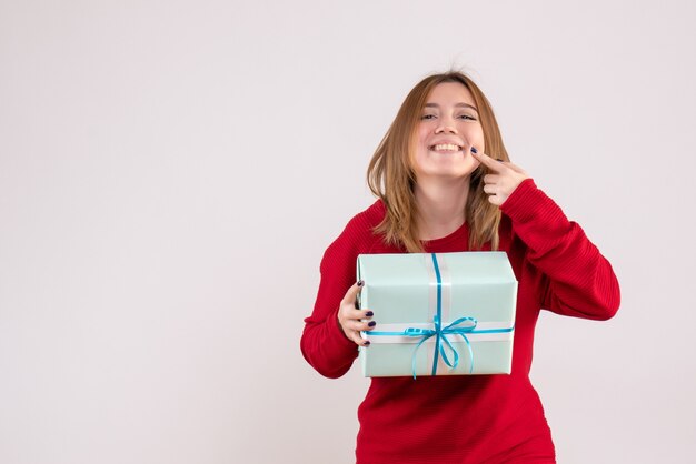 Front view young female standing with xmas present smiling