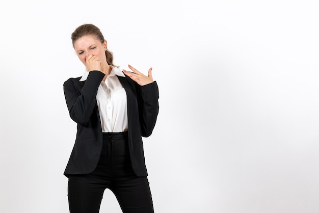 Front view young female in strict classic suit closing her nose on a white background job woman business female suit work