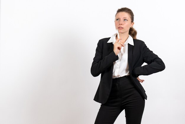 Front view young female in strict classic suit holding pen on white background woman job business female work costume