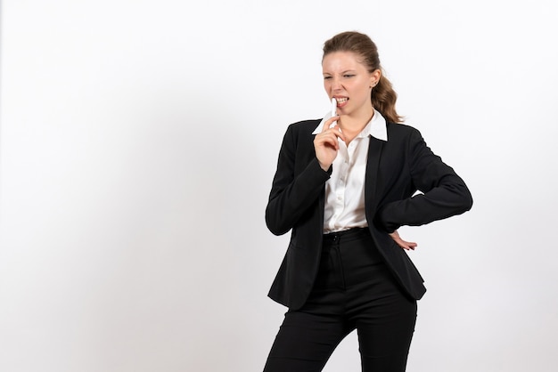 Front view young female in strict classic suit holding pen on a white background woman job costume business female work