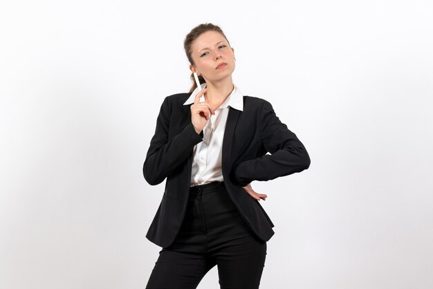 Front view young female in strict classic suit holding pen on white background woman job costume business female work