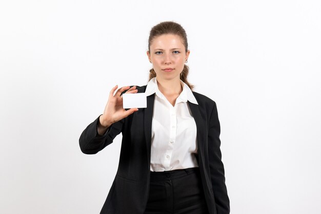 Front view young female in strict classic suit holding white card on the white background job business work costume woman