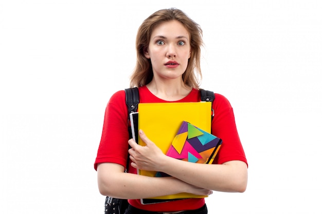 Free photo a front view young female student in red shirt black bag holding copybooks shocked expression on the white