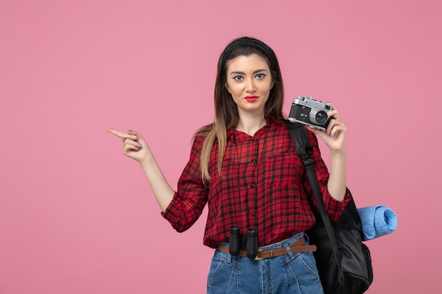 Front view young female taking picture with camera on a pink background woman photo model