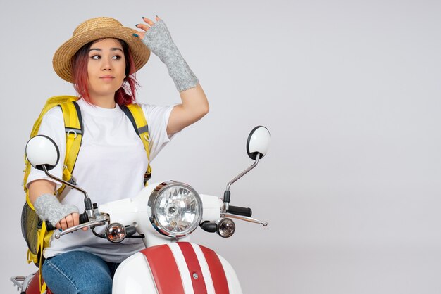 Front view young female tourist sitting on motorcycle on white wall speed woman tourist vehicle photo ride