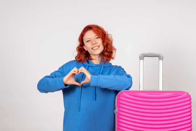 Free photo front view of young female tourist with pink bag on white wall