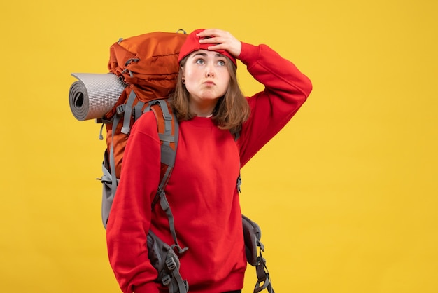 Foto gratuita giovane donna che viaggia da vista frontale con lo zaino che tiene la testa