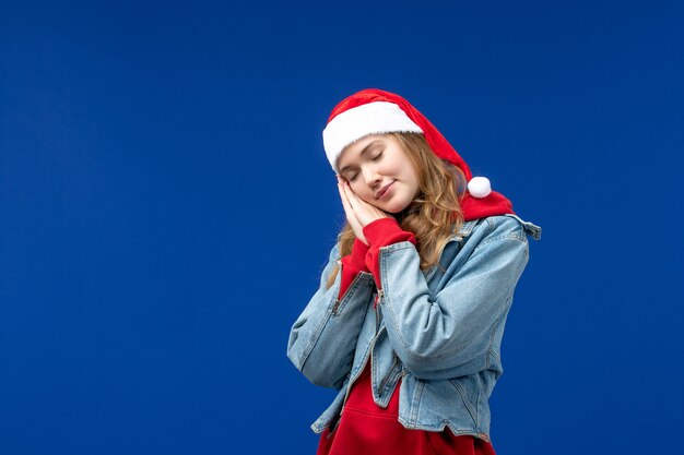 Вид спереди молодая женщина пытается спать на синем фоне эмоции рождественского праздника