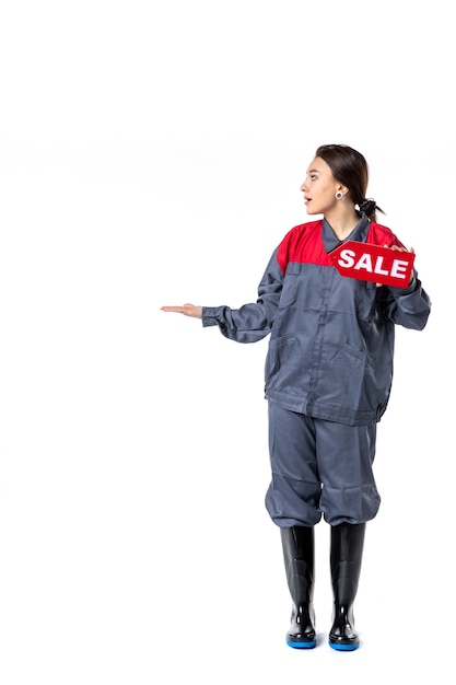 front view young female in uniform holding sale nameplate on white background