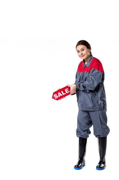 front view young female in uniform holding sale nameplate on white background