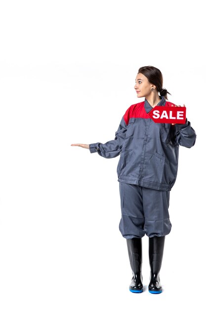 front view young female in uniform holding sale written nameplate on white background