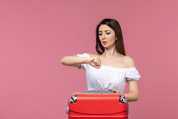 Front view young female in vacation checking time on pink background abroad sea journey travel trip voyage