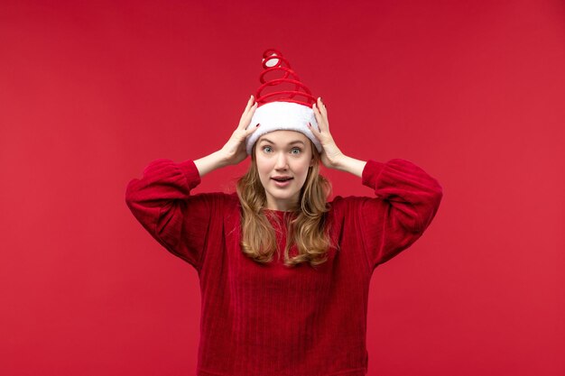 Вид спереди молодая женщина в красной шляпе санта-клауса, праздник рождества