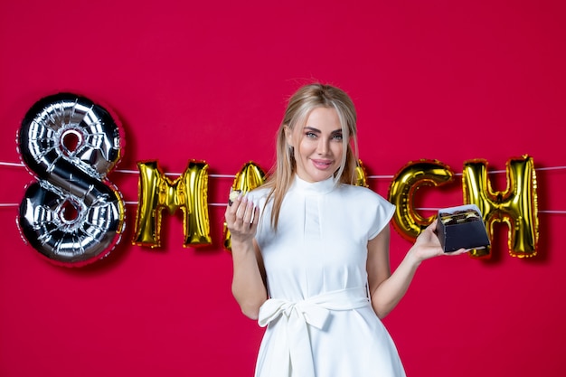 Front view young female in white dress with chocolate candies on red business fun holiday