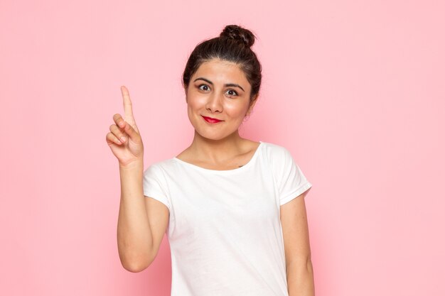 A front view young female in white t-shirt and blue jeans posing with funny expression