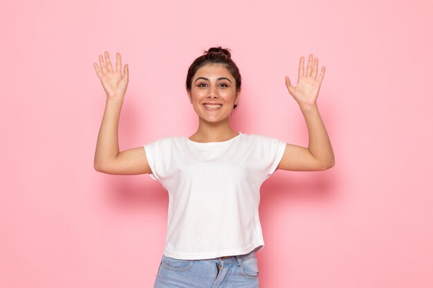 A front view young female in white t-shirt and blue jeans posing with smile