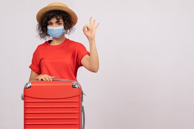 Front view young female with bag in mask on white background color covid- vacation pandemic sun trip tourist