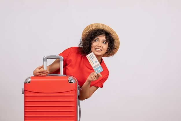 Вид спереди молодая женщина с сумкой, готовящаяся к поездке, держа билет на белом фоне, цветное солнце, путешествие, отдых, отдых, полет, самолет
