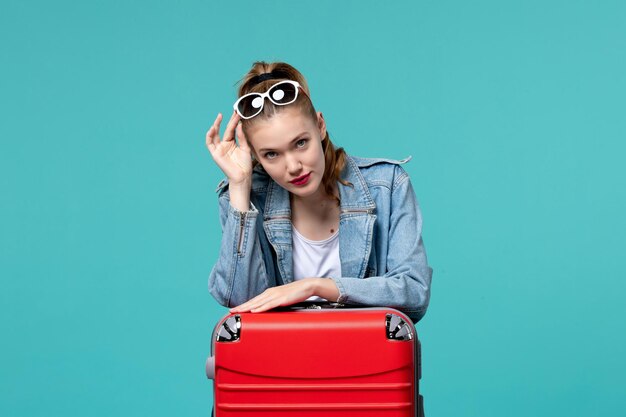 Front view young female with bag preparing for vacation on blue space