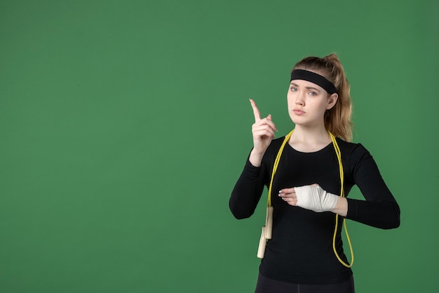 Front view young female with bandage around her hurt arm on green background athlete workout pain health woman injury sport body hospital sad