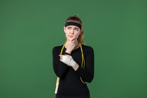 녹색 배경 스포츠 선수 통증 건강 부상 여성 운동 색상에 그녀의 다친 팔 주위에 붕대와 전면보기 젊은 여성