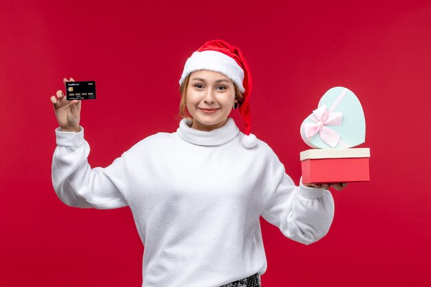 은행 카드와 빨간색 배경에 선물 전면보기 젊은 여성