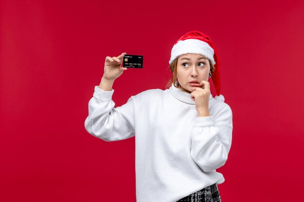 Front view young female with bank card on a red background