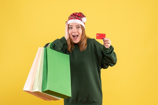 Front view young female with bank card and shopping packages