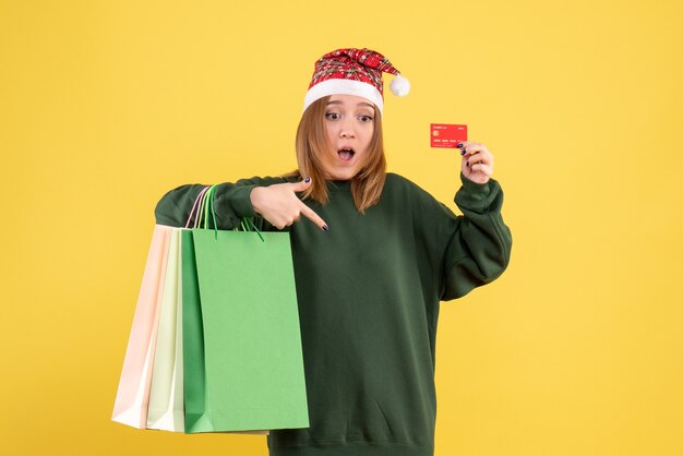 Front view young female with bank card and shopping packages
