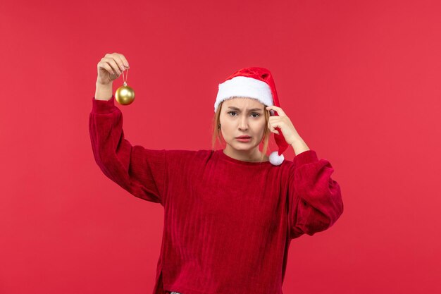 Front view young female with christmas ball toy, red christmas holiday