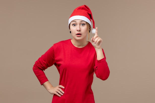 Vista frontale della giovane donna con mantello natalizio su marrone