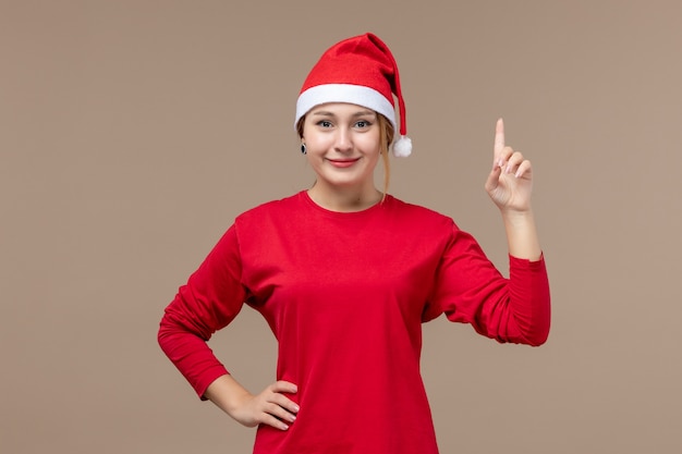 Front view of young female with christmas cape on brown