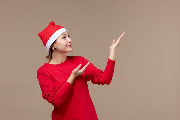 Front view of young female with christmas cape on brown